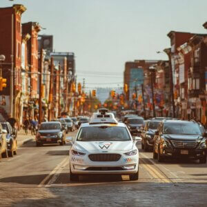 Waymo driverless taxi in traffic on a busy street in Philadelphia, Pennsylvania