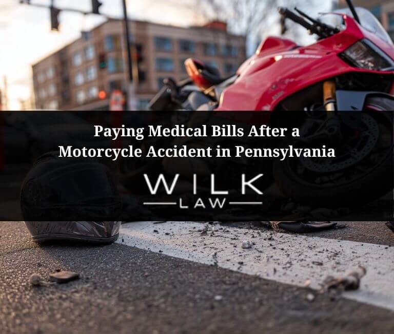 Crashed motorcycle on it's side with a motorcycle helmet on the ground next to it in an intersection in Philadelphia, Pennsylvania