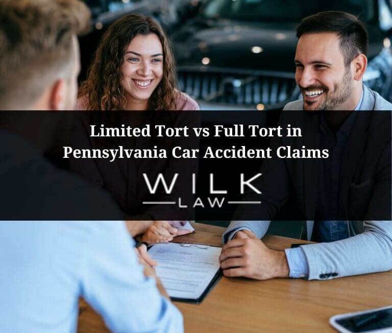 Young couple discussing limited tort vs full tort in Pennsylvania car accident claims with an insurance agent