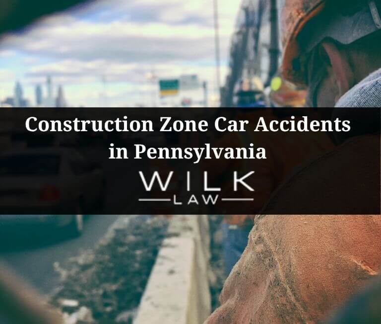 Traffic passing workers in a construction zone on a highway in Philadelphia, Pennsylvania
