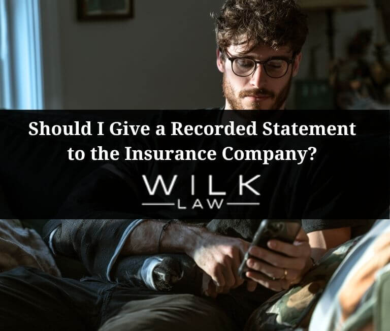 Young man with his arm in a sling on the phone with the insurance company after a car accident in Pennsylvania