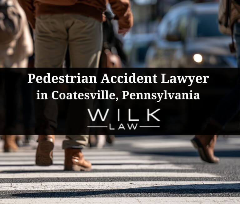 Pedestrians crossing a crosswalk with blurred traffic behind them in Coatesville, Pennsylvania